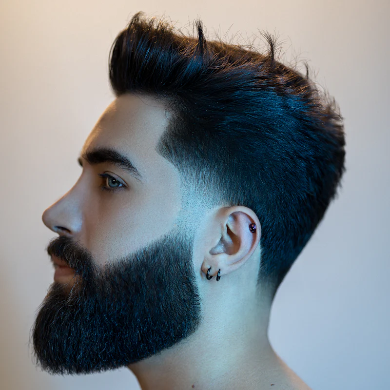 Perfil com degradê baixo e barba cheia bem desenhada