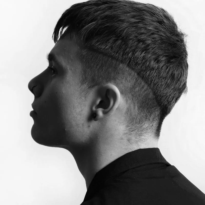 Corte texturizado com risca marcada e laterais baixas, em preto e branco